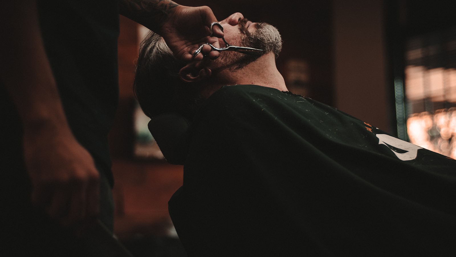 Barber trimming a beard with scissors at Golden Hair Salon